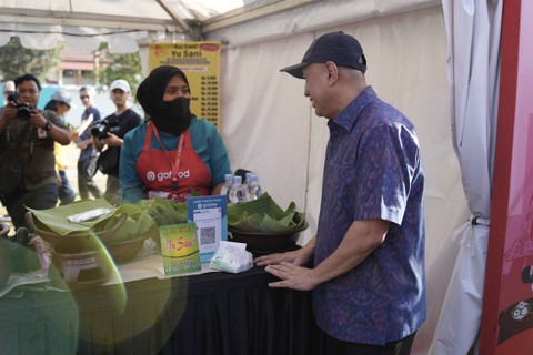 Menkop UKM Teten Masduki berbincang dengan perwakilan mitra usaha GoFood Nasi Liwet "Yu Sani", dalam perayaan Hari UMKM Nasional Expo 2023 di Solo, Sabtu (12/8/2023) Foto: Dok. GoTo