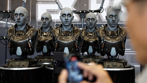 Seorang pengunjung menggunakan telepon di depan robot humanoid yang dikembangkan oleh EXRobots di Beijing World Robot Conference (WRC) 2023 di Beijing, China, 17 Agustus 2023. Foto: Tingshu Wang/Reuters