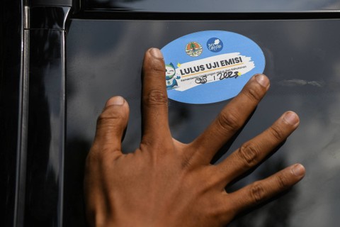 Petugas memasang stiker lolos uji emisi gas buang pada salah satu kendaraan roda empat di Kementerian Lingkungan Hidup dan Kehutanan (KLHK), Senayan, Jakarta, Rabu (23/8/2023). Foto: Aditya Pradana Putra/ANTARA FOTO