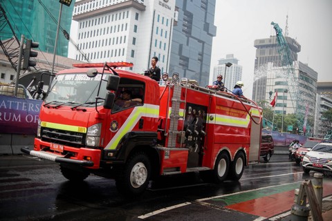 Dinas Penanggulangan Kebakaran dan Penyelamatan (Gulkarmat) DKI Jakarta menyemprotkan air di Jalan M.H. Thamrin, Jakarta Pusat, Jumat (25/8/2023). Foto: Jamal Ramadhan/kumparan