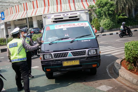 Polisi lalu lintas menghentikan kendaraan saat uji coba razia tilang uji emisi di Terminal Blok M, Jakarta Selatan, Jumat (25/8/2023). Foto: Jamal Ramadhan/kumparan