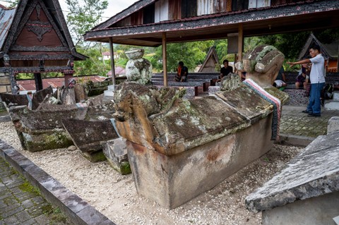 Seorang pemandu wisata memberikan penjelasan kepada wisatawan mancanegara mengenai situs sejarah Makam Tua Raja Sidabutar di Tomok, Pulau Samosir, Sumatera Utara, Senin (28/8/2023). Foto: Ismar Patrizki/Antara Foto