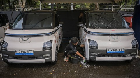 Petugas membersihkan kendaraan listrik yang akan digunakan pada Konferensi Tingkat Tinggi (KTT) ke-43 ASEAN di area Parkir Gelora Bung Karno, Jakarta, Kamis (31/8). Foto: ANTARA FOTO/Galih Pradipta