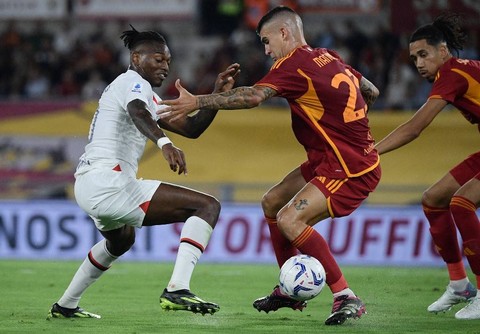 Rafael Leao (kiri) dan Gianluca Mancini (kanan) berduel dalam pertandingan Liga Italia 2023/24 antara AS Roma vs AC Milan di Stadion Olimpico, Roma, pada Sabtu (2/9). Foto: Filippo Monteforte/AFP