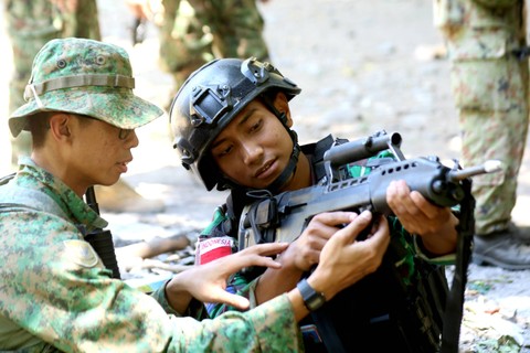 Prajurit korps Marinir TNI AL mengecek senapan serbu bullpup SAR 21 milik tentara Singapore Army pada Latihan Gabungan Bersama (Latgabma) Super Garuda Shield (SGS) di Hutan Selogiri Kalipuro, Banyuwangi, Jawa Timur, Minggu (3/9/2023). Foto: Budi Candra Setya/Antara Foto