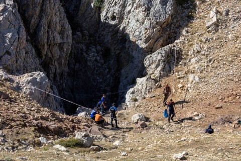Tim penyelamat Turki dan Bulgaria berdiri di pintu masuk Gua Morca saat operasi penyelamatan berlangsung untuk penjelajah gua AS Mark Dickey yang terjebak di dalam gua, dekat Anamur di provinsi Mersin, Turki, Jumat (8/9/2023). Foto: Umit Bektas/REUTERS