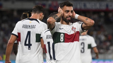 Ruben Dias dan Bruno Fernandes rayakan gol saat laga Slowakia vs Portugal dalam kualifikasi Euro 2024 di National Stadium, Bratislava, pada 9 September 2023. Foto: VLADIMIR SIMICEK / AFP