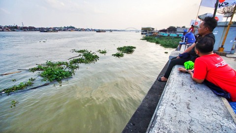 Dua orang pengunjung yang terlihat mengamati tumpukan eceng gondok yang mengambang di pinggir Sungai Musi Palembang, Sabtu (9/9) Foto: ary priyanto/urban id