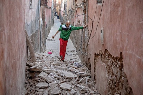 Seorang warga berjalan melewati reruntuhan setelah gempa di Marrakesh, Maroko, Sabtu (9/9/2023). Foto: Fadel Senna/AFP