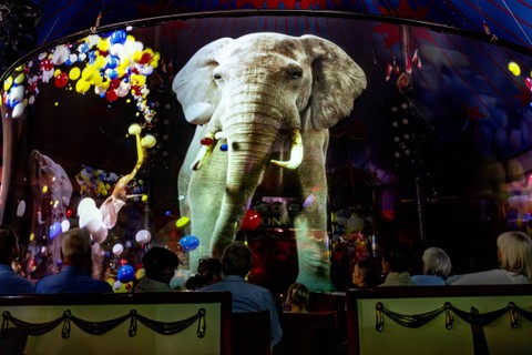 Penonton Pertunjukan Sirkus Roncalli melihat proyeksi hologram seekor gajah saat pertunjukan di Luebeck, Jerman utara. Foto: Axel Heimken/AFP