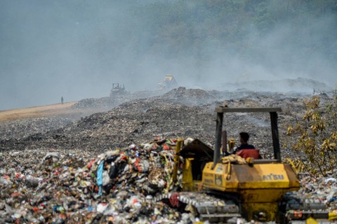Alat berat menimbun sampah dengan tanah di lokasi terbakarnya TPA Sarimukti di Kabupaten Bandung Barat, Jawa Barat, Selasa (12/9/2023). Foto: Raisan Al Farisi/ANTARA FOTO