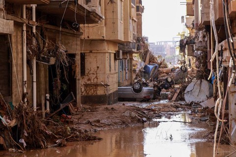 Mobil-mobil yang terbalik tergeletak di antara puing-puing lainnya akibat banjir bandang di Derna, Libya timur, pada 11 September 2023. Foto: AFP