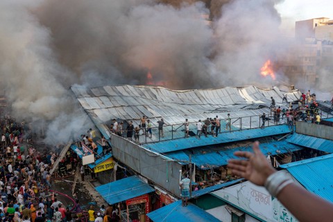 Petugas pemadam kebakaran dan masyarakat bekerja untuk memadamkan api yang terjadi di Pasar Mohammadpur Krishi di, Dhaka, Bangladesh, Kamis (14/9/2023). Foto: Arshadul Hoque Rocky/via REUTERS