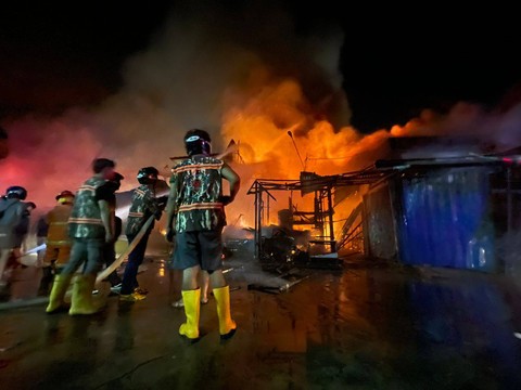 Petugas memadamkan api di kompleks Pasar Sudirman Pontianak. Foto: Leo Prima/Hi!Pontianak