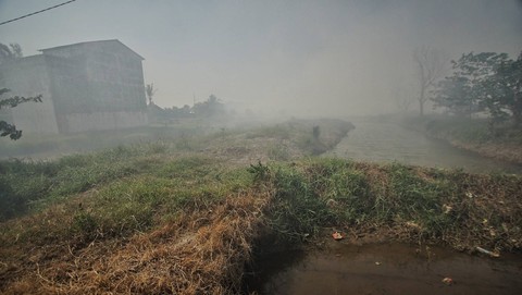 Suasana kabut asap yang menyelimuti area pemukiman warga di Sukawinatan Palembang, Selasa (17/9) Foto: abp/urban id