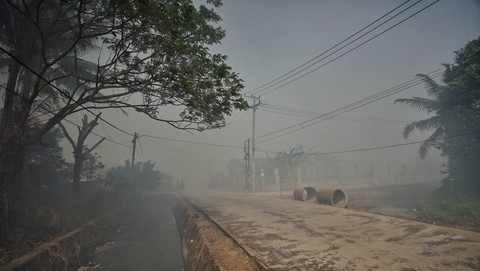 Suasana kabut asap bekas kebakaran lahan yang menyelimuti perkampungan di Palembang, Minggu (17/9) Foto: abp/urban id
