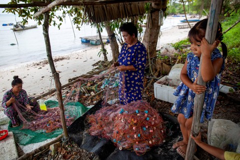 Dua warga memperbaiki jaring ikan di perkampungan nelayan Sembulang, Pulau Rempang, Batam, Kepulauan Riau, Minggu (17/9/2023). Foto: Teguh Prihatna/Antara Foto