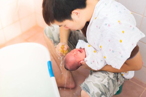 Ilustrasi ayah memandikan bayi. Foto: happybas/Shutterstock