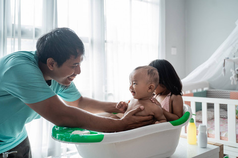 Ilustrasi ayah memandikan bayi. Foto: Odua Images/Shutterstock