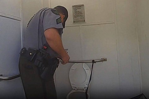Seorang sersan Departemen Sumber Daya Alam berbicara dengan seorang wanita yang terjebak di toilet kakus setelah mencoba mengambil Apple Watch-nya di Danau Dixon di Bagley Township, Michigan, Selasa, 19 September 2023,  Foto: Michigan State Police via AP