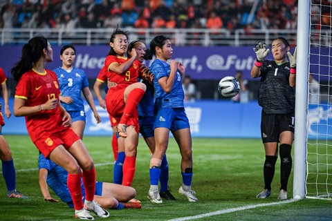 Penjaga gawang Mongolia Erdenebileg Tsendjav (kanan) mencoba menangkap bola saat pertandingan melawan Tiongkok untuk pertandingan sepak bola mereka selama Asian Games Hangzhou 2022 di Stadion Linping Sport Center, di Hangzhou. Foto: Hector Retamal / AFP