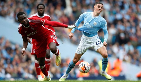 Moussa Niakhate dan Phil Foden berduel di laga Man City vs Nottingham Forest dalam laga pekan keenam Liga Inggris 2023/24 di Stadion Etihad, Sabtu (23/9/2023) malam WIB. Foto: Action Images via Reuters/Ed Sykes