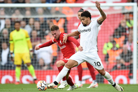 Pemain Liverpool Alexis Mac Allister berebut bola dengan pemain West Ham United Lucas Paqueta pada pertandingan lanjutan Liga Inggris di Anfield, Liverpool, Inggris, Minggu (24/9/2023).  Foto: Peter Powell/REUTERS