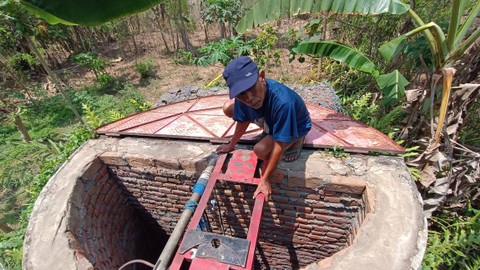 Warga menunjukkan sumur yang digunakan untuk pam dusun untuk mengatasi kekeringan dengan ngeleb (membasahi daratan) di sekitar sumur dengan air dari Kali Progo, Selasa (3/10/2023). Foto: Arfiansyah Panji Purnandaru/kumparan