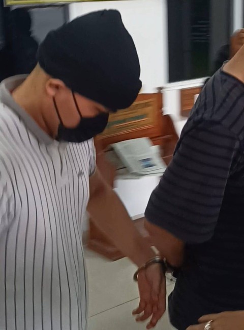 Sembari tangannya diborgol AKP Andri Gustami digiring menuju mobil tahanan. | Foto : Galih Prihantoro/ Lampung Geh