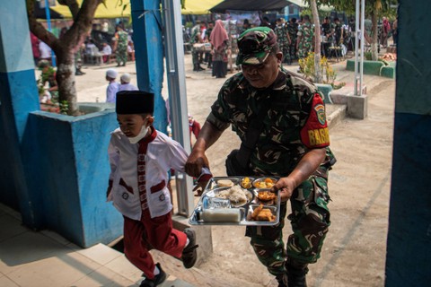 Prajurit TNI AD membantu siswa Sekolah Dasar (SD) mengambil makanan saat pelaksanaan program dapur masuk sekolah di SD Negeri 205, Kertapati, Palembang, Sumatera Selatan, Jumat (6/10/2023). Foto: Nova Wahyudi/ANTARA FOTO