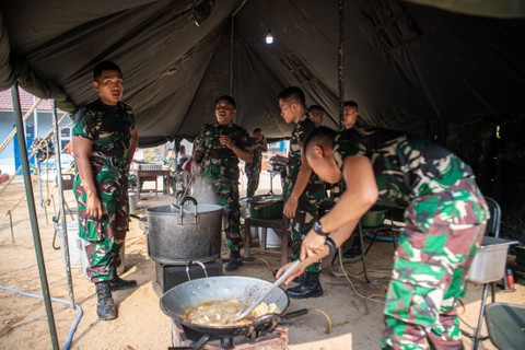 Sejumlah prajurit TNI AD memasak makanan saat pelaksanaan program dapur masuk sekolah di SD Negeri 205, Kertapati, Palembang, Sumatera Selatan, Jumat (6/10/2023). Foto: Nova Wahyudi/ANTARA FOTO