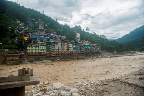 Sisa-sisa jembatan yang menghubungkan Adarsh gaon dengan Singtam digambarkan di sepanjang tepi Sungai Teesta di Singtam di Sikkim, India, Kamis (5/10/2023). Foto: Wang Chen/REUTERS