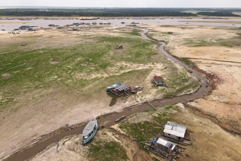 Perahu dan rumah perahu terlihat terdampar di Danau Tefe, yang terkena dampak kekeringan, di Tefe, negara bagian Amazonas, Brasil, 3 Oktober 2023. Foto: Bruno Kelly/REUTERS