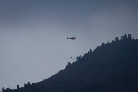 Helikopter Badan Nasional Penanggulangan Bencana (BNPB) membawa air untuk memadamkan kebakaran hutan Gunung Lawu di Jenawi, Karanganyar, Jawa Tengah, Jumat (6/10/2023). Foto: Mohammad Ayudha/Antara Foto