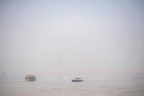 Perahu tradisional melewati Sungai Musi yang tertutup kabut asap di Palembang, Sumatera Selatam, Sabtu (7/10/2023). Foto: Nova Wahyudi/Antara Foto