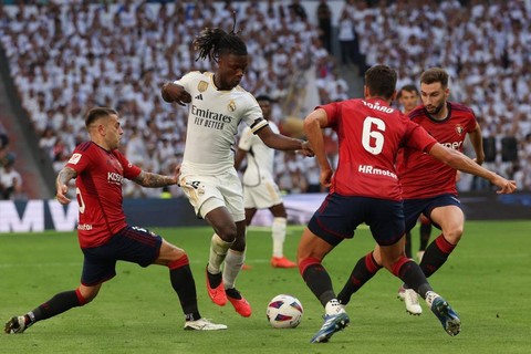 Eduardo Camavinga (tengah) berduel dengan dalam pertandingan Liga Spanyol 2023/24 antara Real madrid vs Osasuna di Stadion Santiago Bernabeu, Madrid, Spanyol, pada Sabtu (7/10). Foto: Pierre-Philippe Marcou/AFP