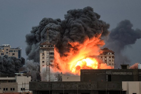 Api dan asap membubung di atas gedung-gedung selama serangan udara Israel di Kota Gaza, Sabtu (7/10/2023).  Foto: MAHMUD HAMS/AFP
