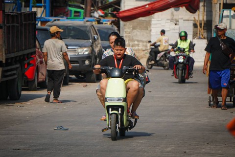 Aktivitas warga menggunakan kendaraan listrik di kawasan Kalibaru, Cilincing, Jakarta Utara pada Minggu (8/10/2023). Foto: Iqbal Firdaus/kumparan