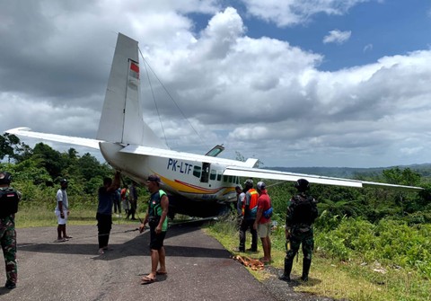 Petugas dan warga menyaksikan Pesawat Asian One dengan kode penerbangan PK-LTF yang mengalami kecelakaan saat hendak lepas landas dari Bandara Kenyam di Kabupaten Nduga, Papua Pegunungan, Senin (9/10/2023). Foto: Humas Polres Kenyam/HO/ANTARA FOTO