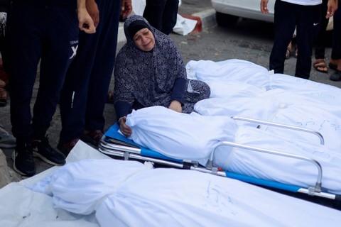 Seorang wanita berduka di samping jenazah warga Palestina yang tewas dalam serangan Israel, di sebuah rumah sakit di Kota Gaza, Rabu (11/10/2023). Foto: Mohammed Salem/REUTERS