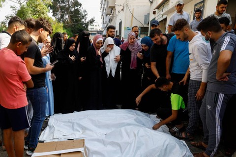 Keluarga dan kerabat berkumpul di samping jenazah warga Palestina yang tewas dalam serangan Israel, di sebuah rumah sakit di Kota Gaza, Rabu (11/10/2023). Foto: Mohammed Salem/REUTERS