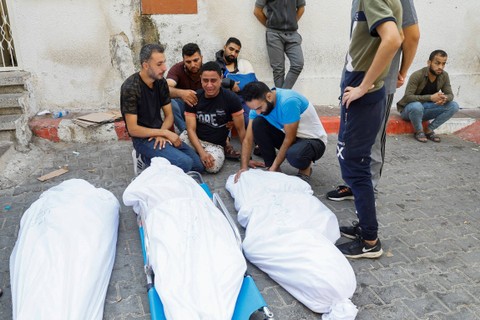 Keluarga dan kerabat berduka di samping jenazah warga Palestina yang tewas dalam serangan Israel, di sebuah rumah sakit di Kota Gaza, Rabu (11/10/2023). Foto: Mohammed Salem/REUTERS