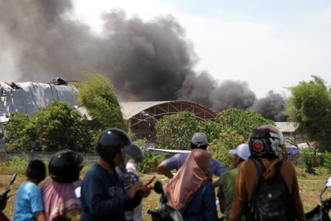 Warga melihat api yang membakar pabrik tisu PT Sun Paper Source (SPS) di Desa Kembangringgit, Pungging, Mojokerto, Jawa Timur, Kamis (12/10/2023). Foto: Umarul Faruq/ANTARA FOTO