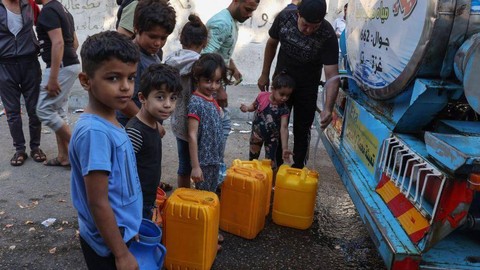 Warga Palestina mengisi jerigen mereka dengan air dari tempat pengumpulan air umum di Kota Gaza, Kamis (12/10).