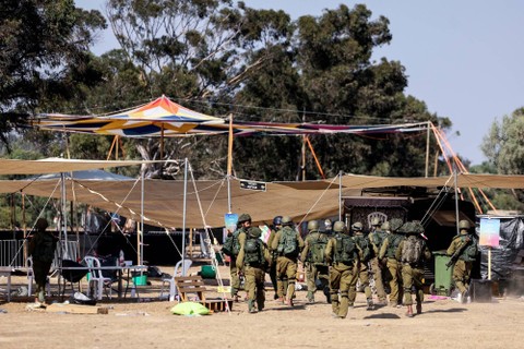 Tentara Israel berkumpul di lokasi serangan terhadap Festival Nova oleh Hamas dari Gaza, di dekat perbatasan Israel dengan Jalur Gaza, di Israel selatan, Kamis (12/10/2023). Foto: Ilan Rosenberg/REUTERS
