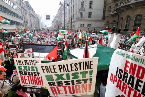 Demonstran mengikuti aksi solidaritas dengan Palestina, di tengah konflik yang sedang berlangsung antara Israel dan kelompok Islam Palestina Hamas, di London, Inggris, Sabtu (14/10/2023). Foto: Toby Melville/REUTERS