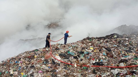 Petugas masih berupaya memadamkan api di tengah kepulan asap di TPA Bakung, Bandar Lampung. | Foto : Dok. Dinas Pemadam Kebakaran dan Penyelamatan Kota Bandar Lampung.