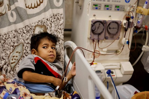 Seorang pasien ginjal Palestina duduk di ranjang rumah sakit Naser di Khan Younis di selatan Jalur Gaza, Minggu (15/10/2023). Foto: Mohammed Salem/REUTERS