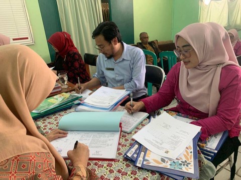 Roy (tengah), penderita nyeri sendi leher saat bekerja di sekolah.  Foto: Dok. Istimewa