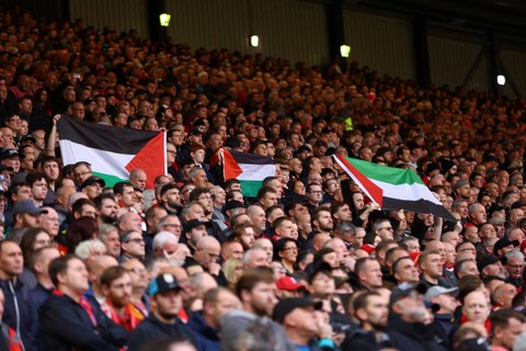 Penggemar di dalam stadion mengibarkan bendera untuk mendukung Palestina saat pertandingan Liverpool vs Everton di Stadion Anfield, Liverpool, Inggris, Sabtu (21/10/2023). Foto: Carl Recine/REUTERS